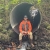 Andy Stevens sitting at the end of a culvert with water running through it. 