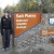 Visitor Services Specialist Melissa Robell standing beside Salt Plains NWR Office/Visitor Center sign