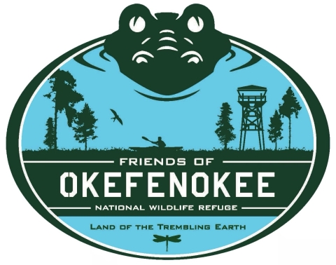 The Friends of Okefenokee National Wildlife Refuge Logo colored green and blue with an alligator, trees, dragonfly, and tower with the words "Land of the Trembling Earth" at the bottom. 