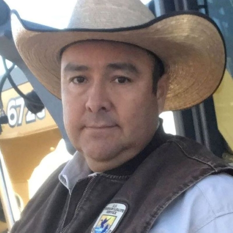 A portrait of man in a hat and a U.S. Fish and Wildlife Service uniform