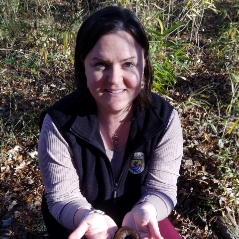 Jennifer outdoor holding a brown salamander.