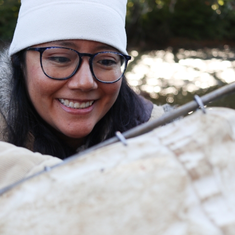 Smiling biologist looking into a D-frame kick net