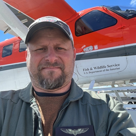 Man (Ken Richkus) taking a selfie in front of a plane