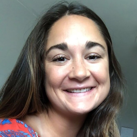 Picture of a female wearing a colorful shirt at an office setting.