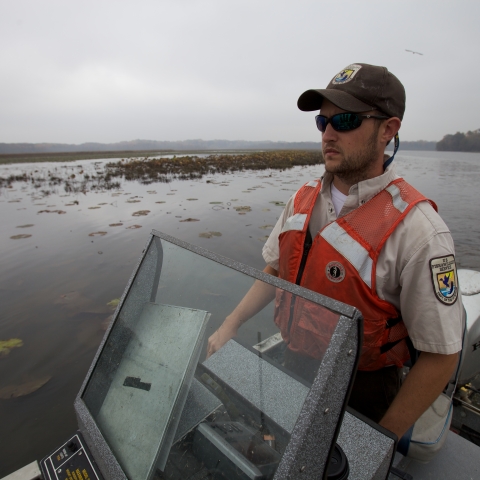 Fish biologist driving electrofishing boat