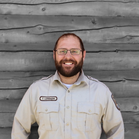 a man in uniform by a cabin wall