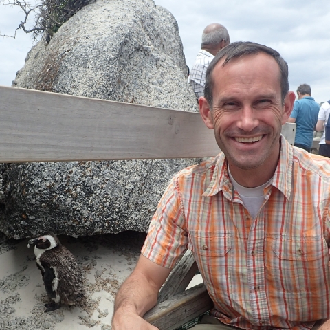 Dan Blake beside a penguin