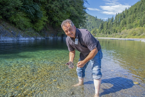 a man in water with sand in his hand