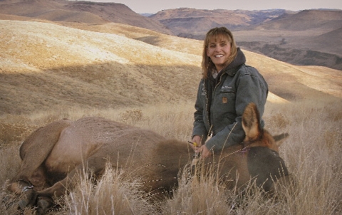 a woman holding an unconscious elk