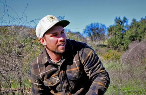 A man wearing a flannel shirt and baseball cap