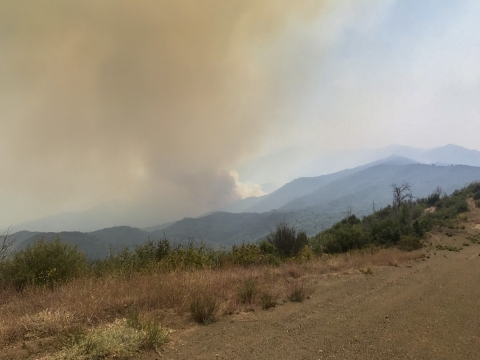 Smoke rises above the mountains