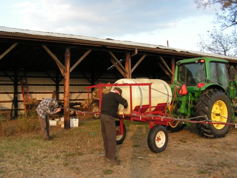 two maintenance guys working on a sprayer