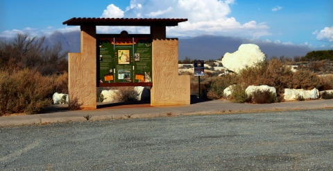 kiosk, large white rock and white cloudy in a blue sky