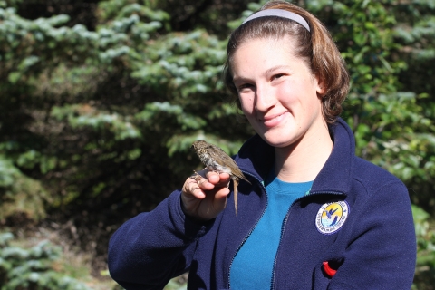 smiling woman holds a small bird