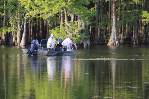 Two women catch bass from boat at Santee NWR