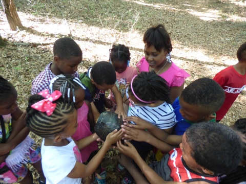 Elementary students touch yellow-bellied slider turtle during reptile program at Santee NWR. 