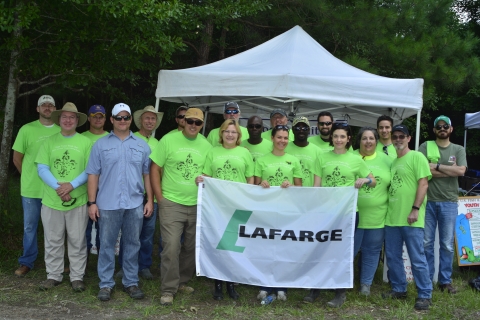 group of women and men standing and holding a banner