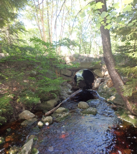 undersized pipe culvert with rocky stream