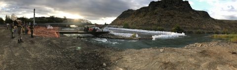 Panoramic view of people in waders approaching a project site.