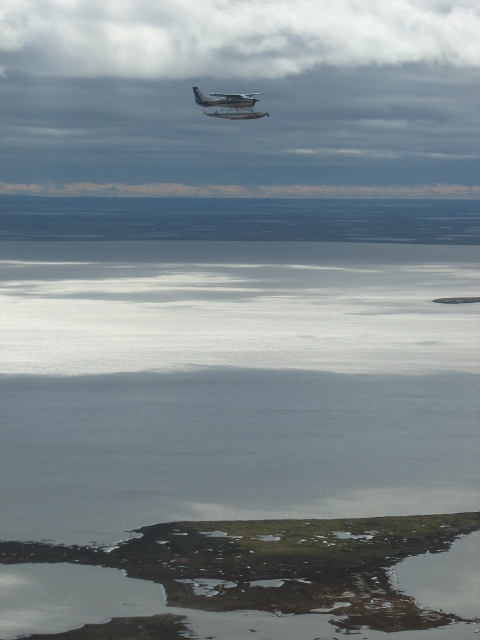 Airplane on amphibious floats flying over a lake