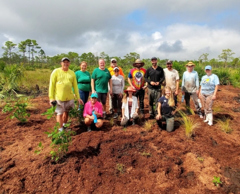 Volunteers posing for a group photo after working in a garden.