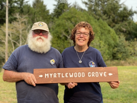 Refuge volunteers hold a sign they made for a nature trail