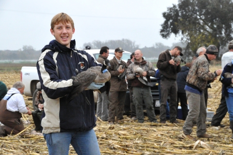 Person standing holding a goose.