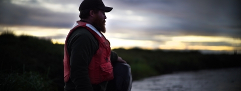 man in PFD on a river boat