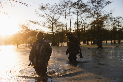 Part of the Four W's team walking through marsh as they duck hunt at Trinity River National Wildlife Refuge.