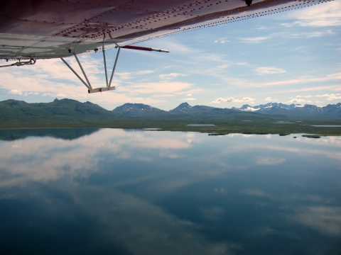 a sprawling lake with mountains in the background, as seen by a plance