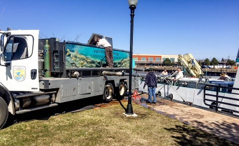 Biologist off-loading lake trout from Pendills Creek NFH onto the stocking vessel, the MV Spencer F. Baird