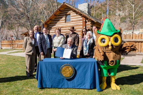 A group of people standing behind Nevada governor Steve Sisolak during a document signing event