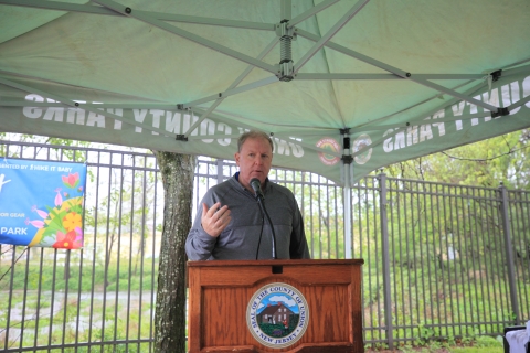 A man speaks at a podium under a ten