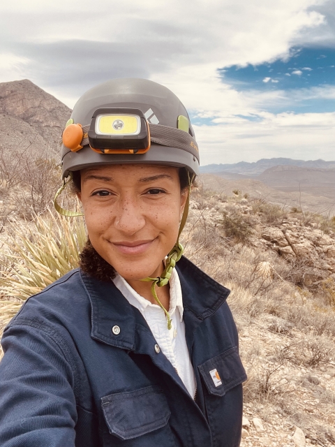 biologist takes selfie in front of mountain landscape