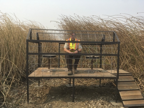 a man sits in a metal wire box