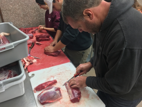 Mentored deer hunt participant Jeff Patten processes harvested venison