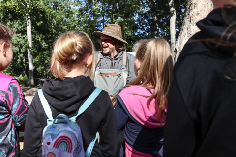 Lone biologist, smiling, standing in front of a group of students