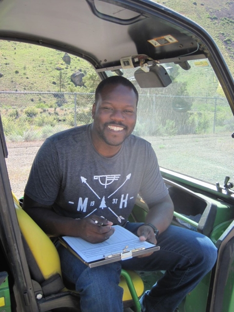 Rikeem Sholes, fish biologist, sitting in an OHV 