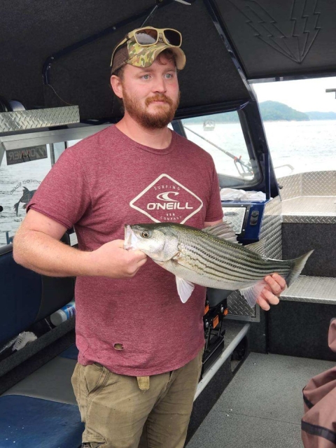 Wounded Warrior Fishing Derby participant holding striper