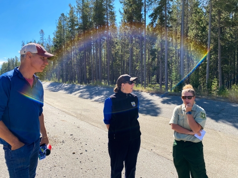 man in baseball hat standing next to woman with USFWS logo next to woman with USFS logo