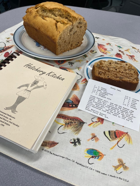 Cookbook on a table with a fresh baked cake