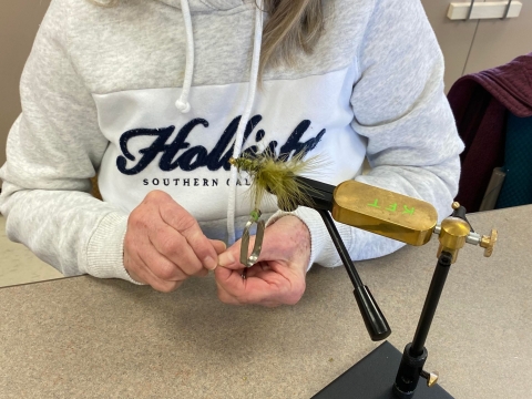 Green fly held in a fly-tying vice