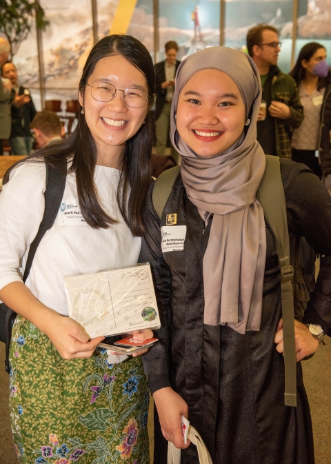 Two younger women hold a certificate. 