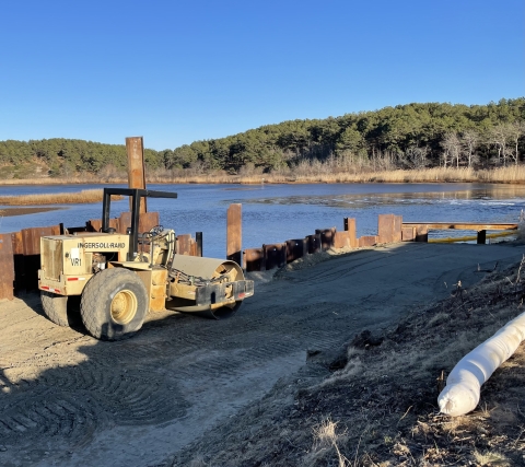 A road roller beside a river