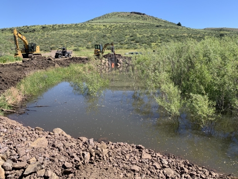 Construction equipment in the background a streambed