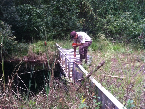 Man standing on a water control structure