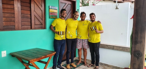 Four people in yellow t-shirts hold power line markers.