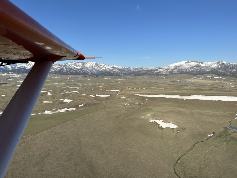 view of an airplane wing over the Crazy Mountains