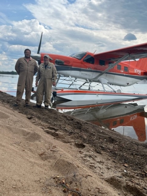 two people standing in front of an airplane