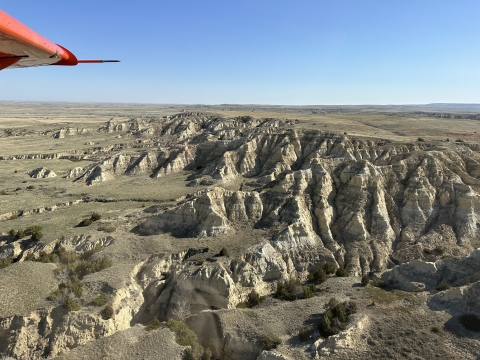 view of an airplane wing over the landscape in Montana